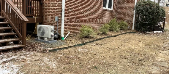 Post-installation view of basement waterproofing system during winter, showing sealed walls and dry surroundings