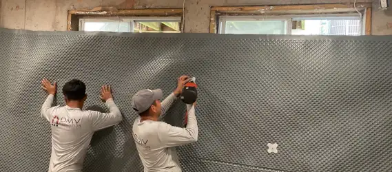 Drainboard panel installed in crawlspace to block moisture and redirect seepage to drainage system.